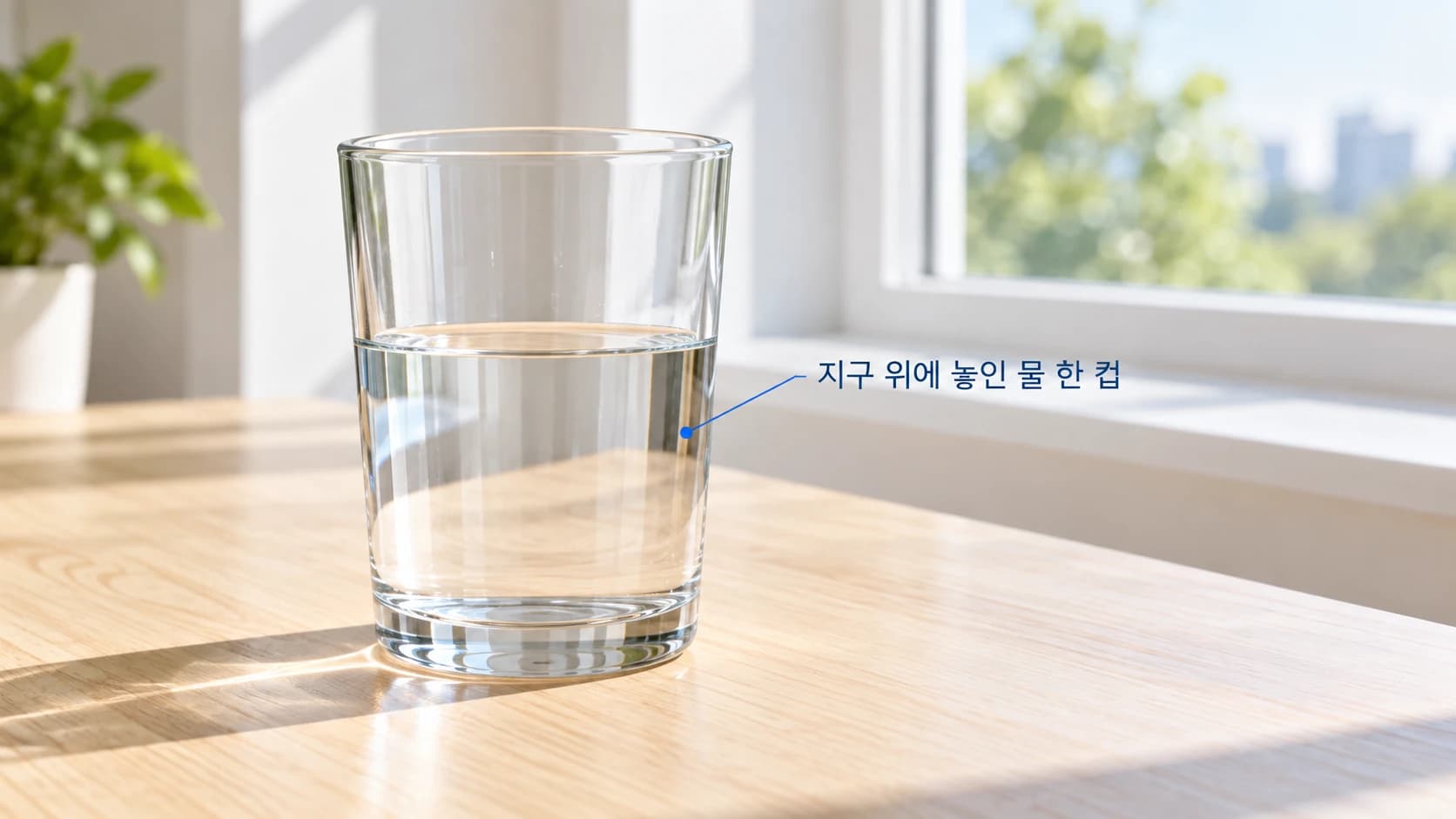 밝은 방의 창가 책상 위에 물이 담긴 투명한 컵이 놓여 있다. 컵의 위아래가 모두 보인다.